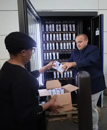 Photo of Metro Health Department Employees stocking Naloxone vending machine
