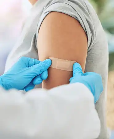 photo of doctor applying a band-aid after giving a shot