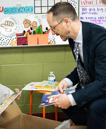 Mayor Freddie O'Connell looking at books with a child in a classroom