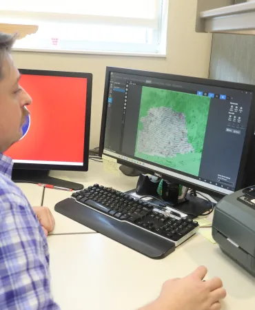 Technician encoding a latent print for database entry and search