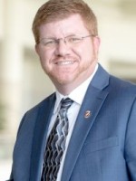 Man with glasses in a suit.